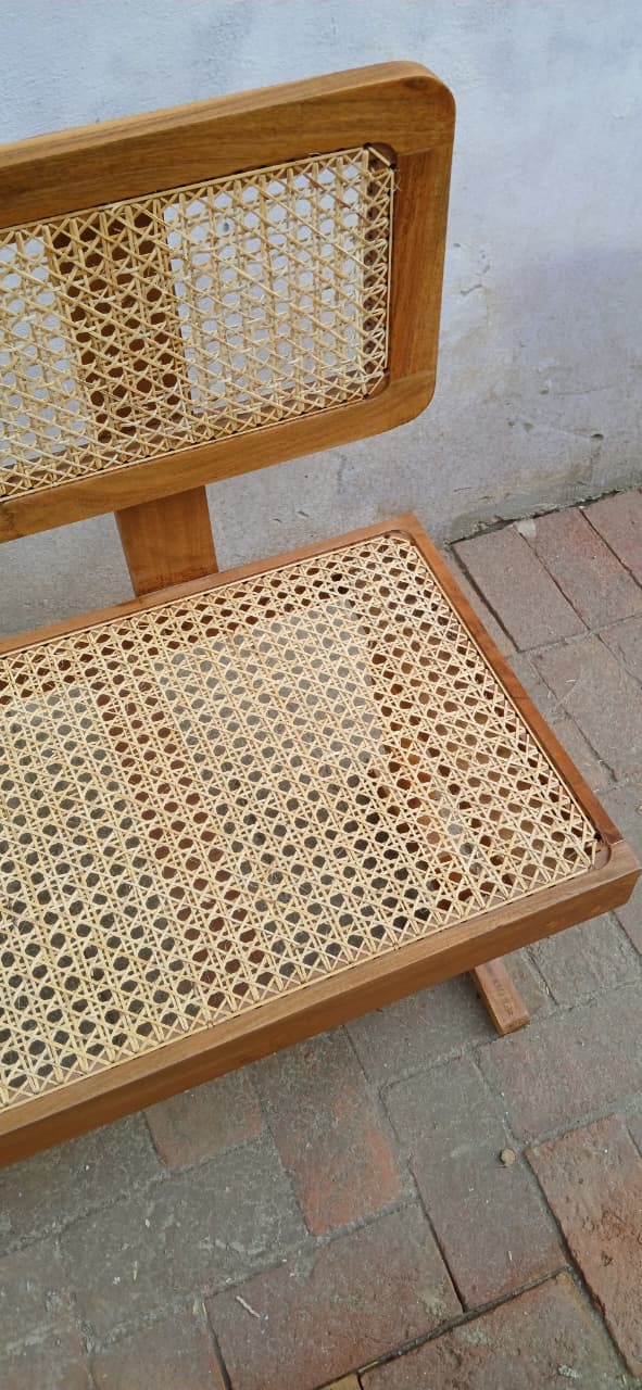 Close-up of hand-woven cane seating surface on Wevo bench