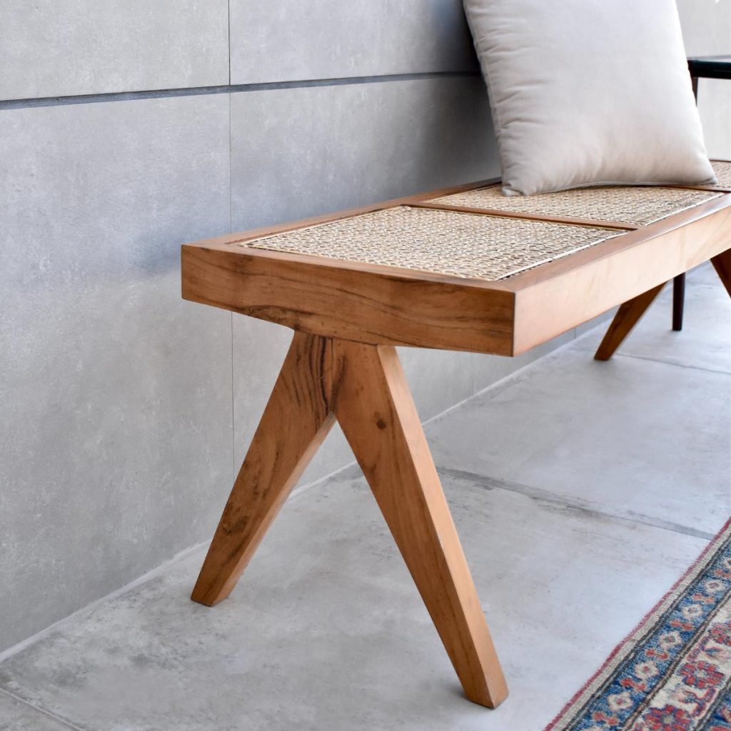 "Close-up of handwoven cane seat on rattan bench"