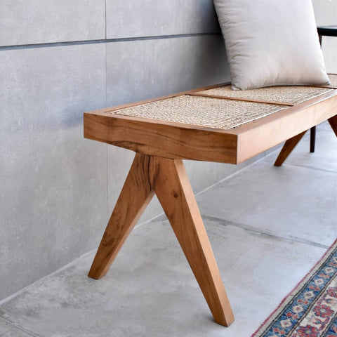 "Close-up of handwoven cane seat on rattan bench"