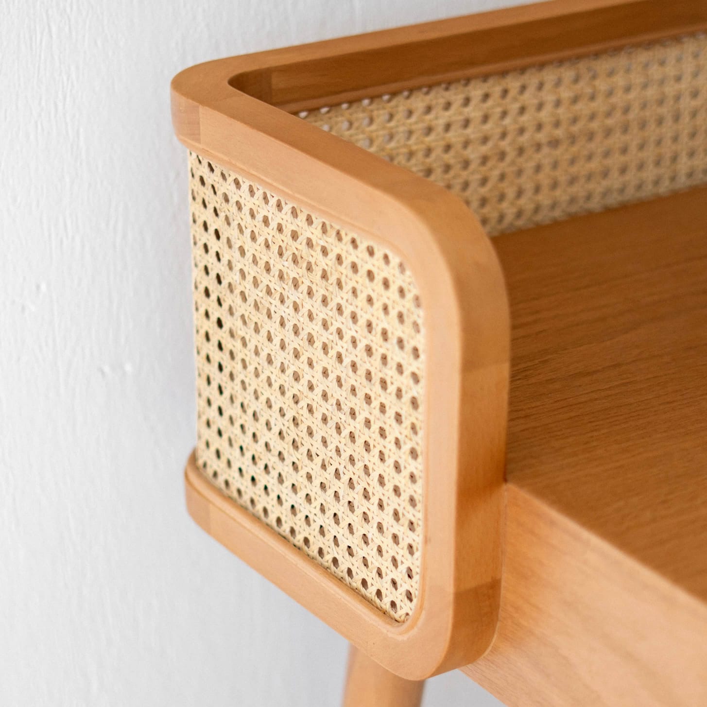 Close-up of wood grain and cane weave texture on Canelin table