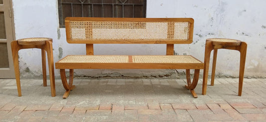 Front view of Wevo rattan bench showing woven cane seat