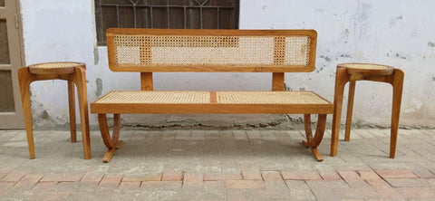 Front view of Wevo rattan bench showing woven cane seat