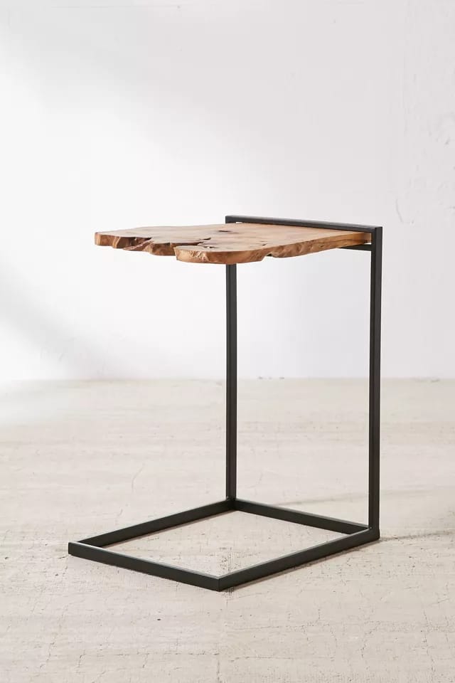 Live edge wood side table styled beside a bed