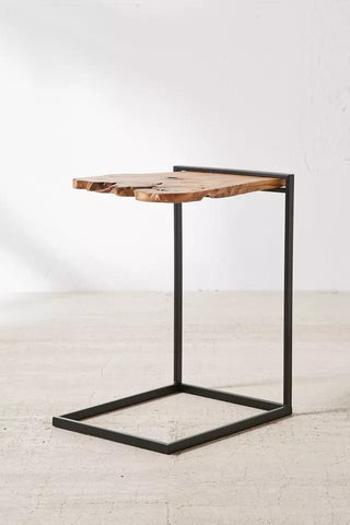 Live edge wood side table styled beside a bed