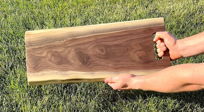 Live edge wood tray with cut-out handles, angled view