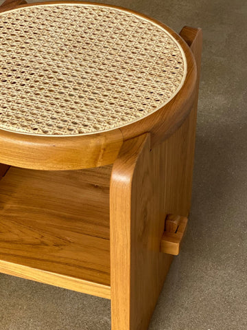 "Rattan side table styled next to sofa"
