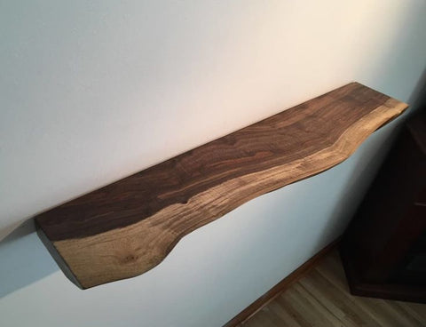 Wooden floating shelf mounted on wall with bracket