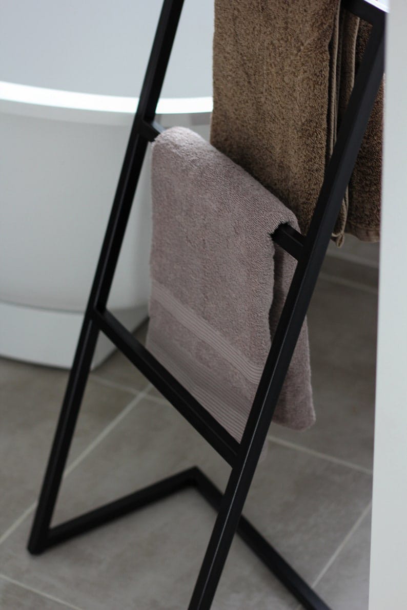 metal towel stand holding folded towels